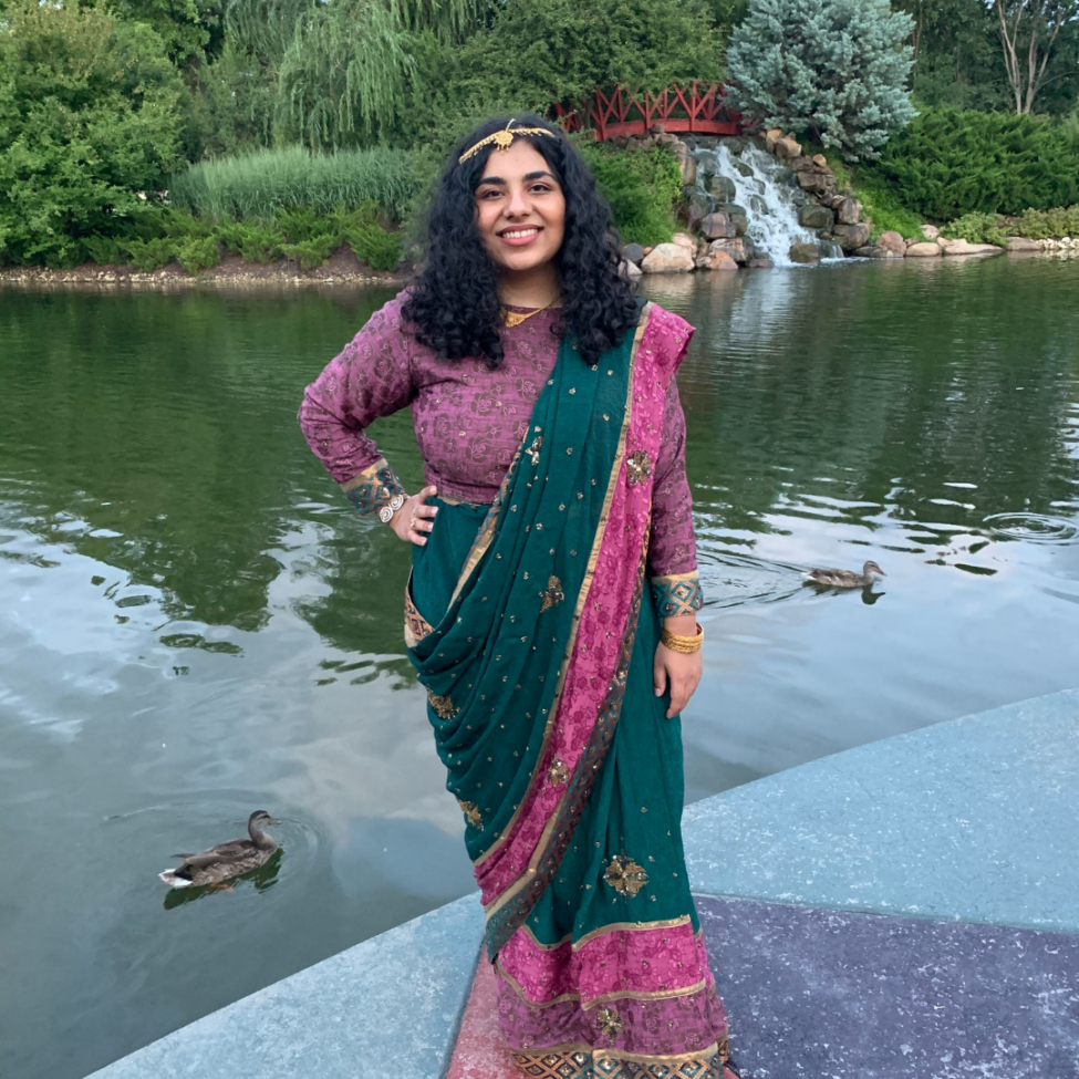 Young asian woman posing in front of a pond in traditional Bangladeshi clothing