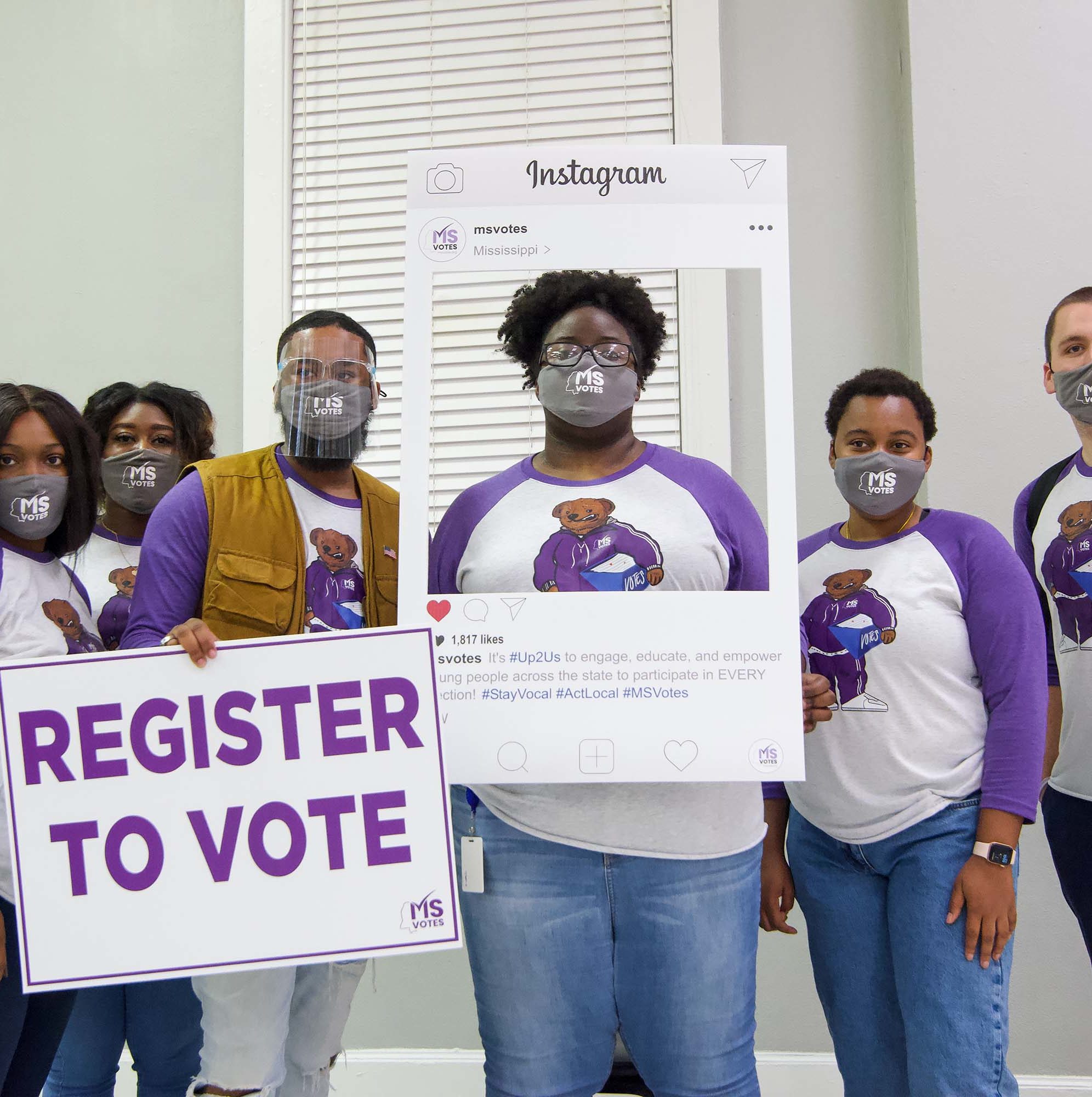group of MS Votes holding up a register to vote sign